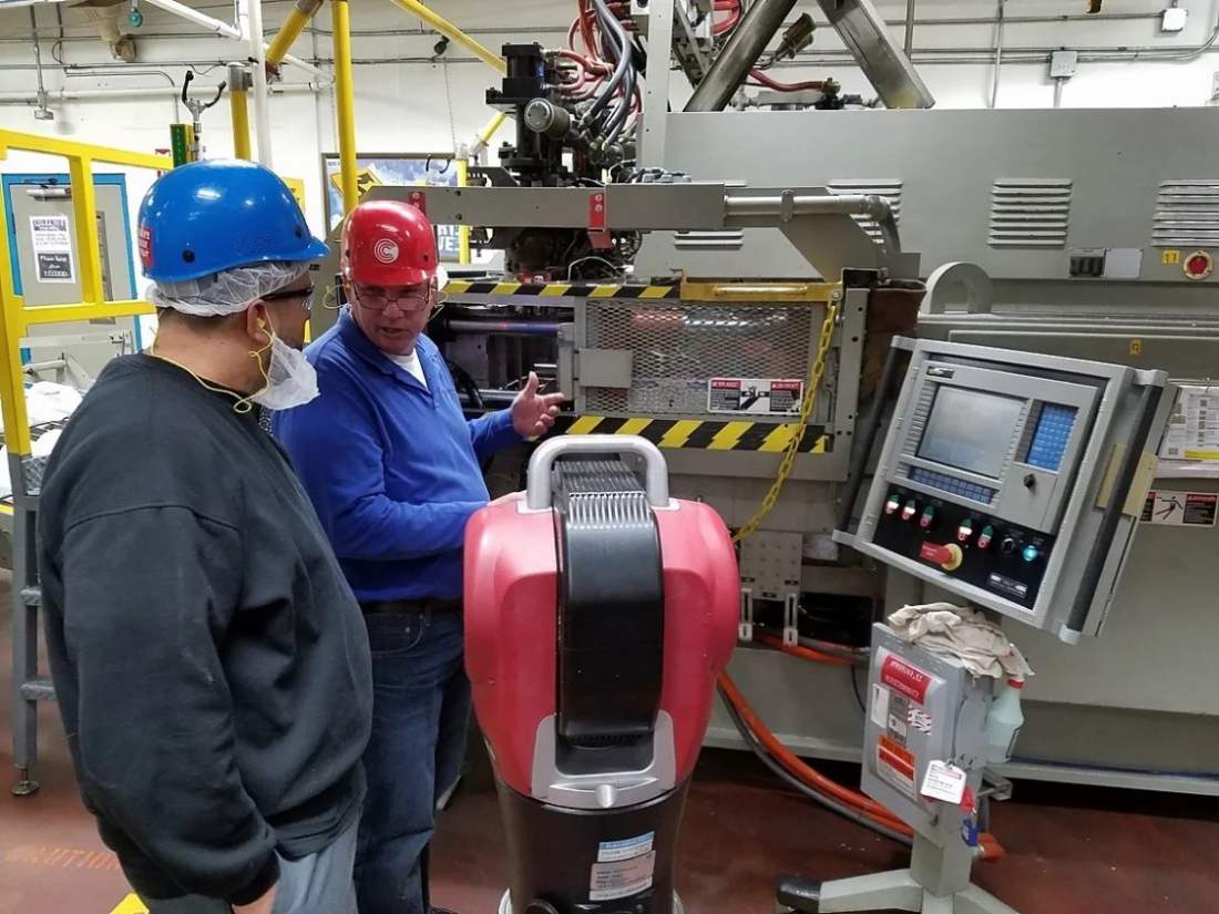 Automotive technicians aligning a production machine with a laser tracker during line commissioning